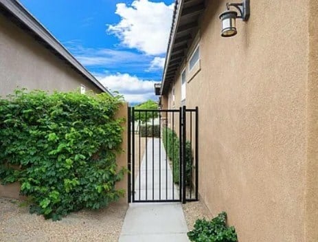A black gate with a metal railing is closed.