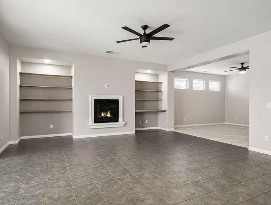 A spacious living room with a fireplace and built-in shelves.