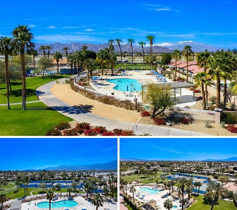 A large swimming pool surrounded by palm trees and a mountain in the distance.