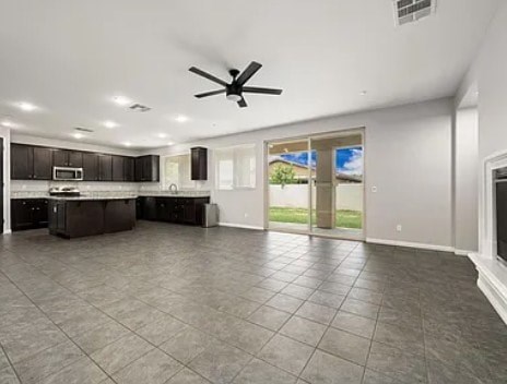 A spacious kitchen with dark brown cabinets and a tiled floor.
