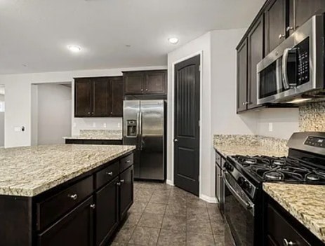 A kitchen with black cabinets and granite countertops.