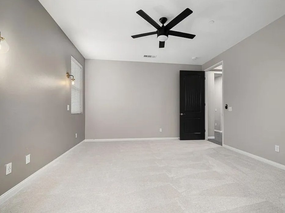 A room with a ceiling fan and a black wardrobe.