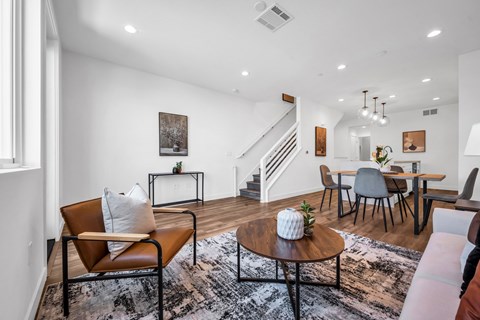A living room with a brown leather chair and a coffee table with a plant on it.