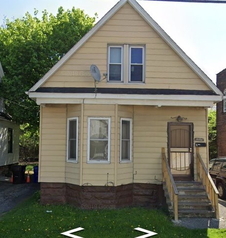 A small house with a brown door and a satellite dish on the roof.