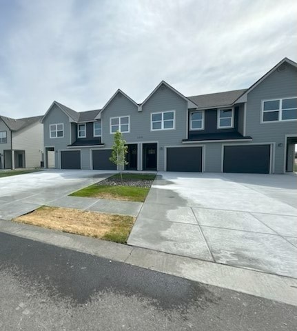 A row of houses with a tree in the front yard.
