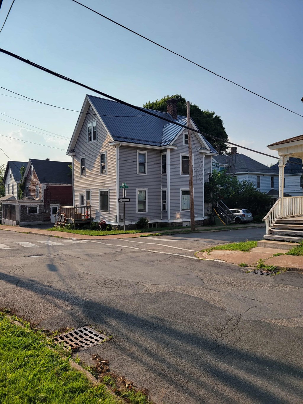 A house with a grey roof and a white car parked in front.
