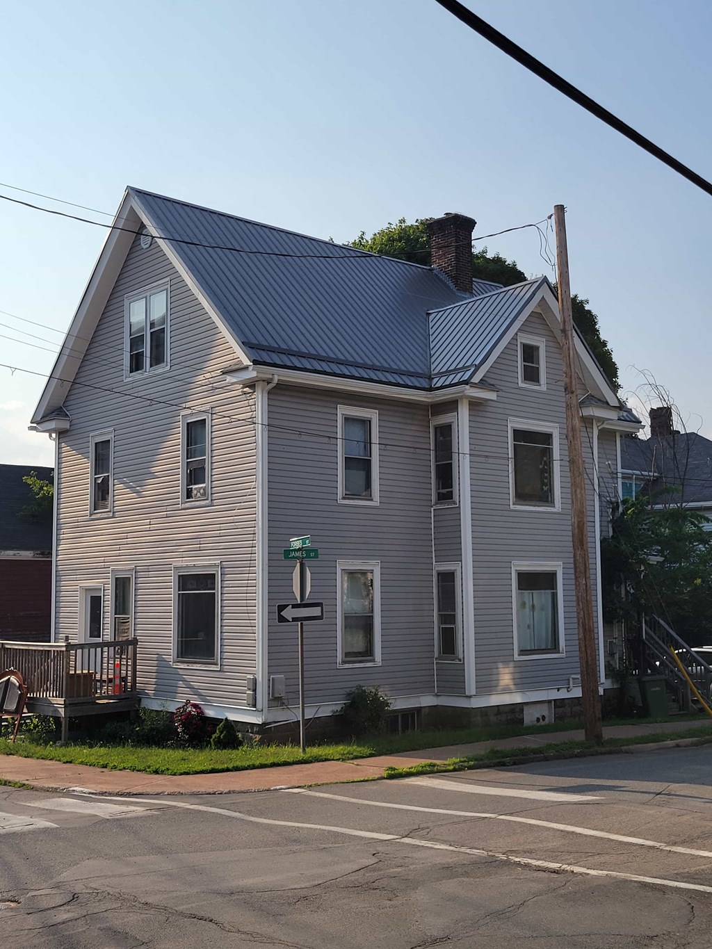 A two-story house with a grey exterior and a blue roof.