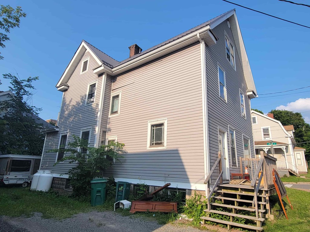 A house with a grey siding and a brown roof.