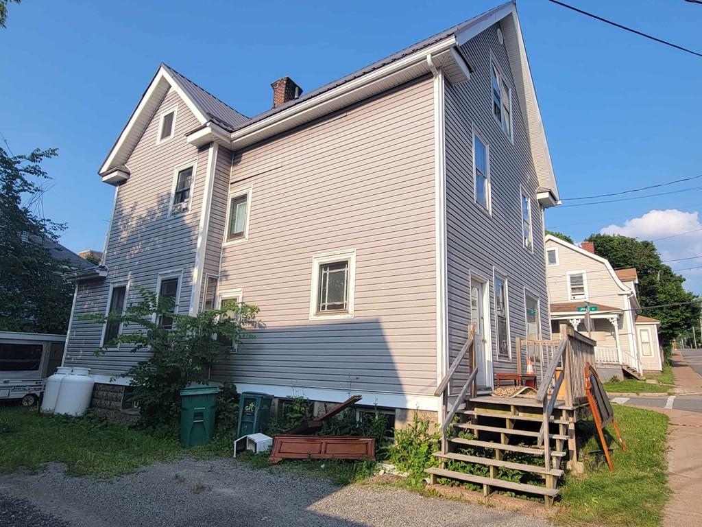A house with a grey siding and a brown roof.