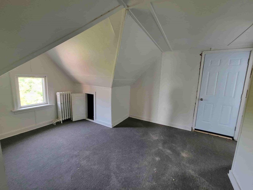 A room with a white door and a window with blinds.