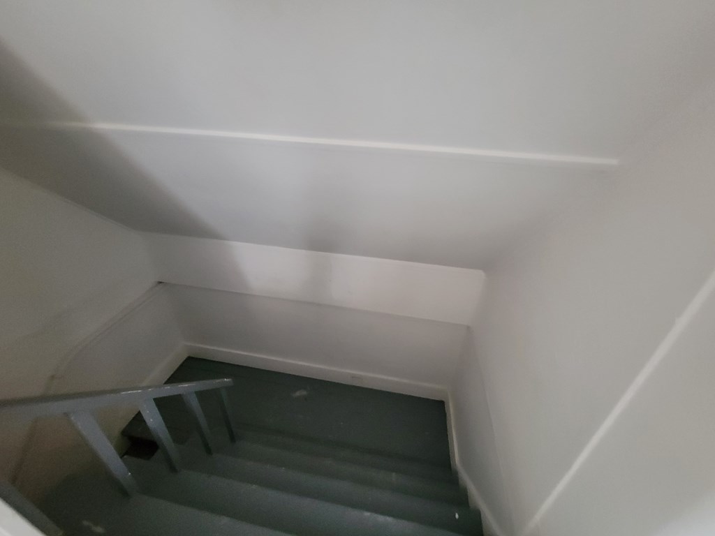 A staircase with a metal railing and grey steps.