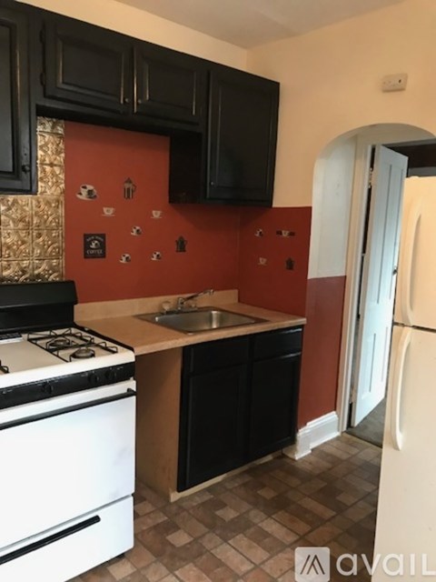 A kitchen with black cabinets and a white stove top oven.