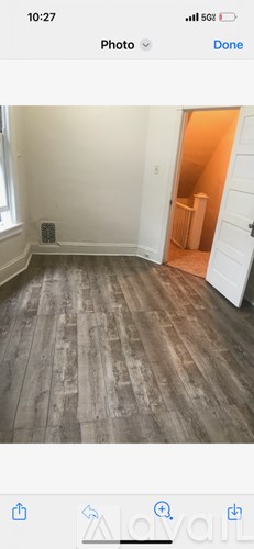 A room with wooden flooring and a white door.