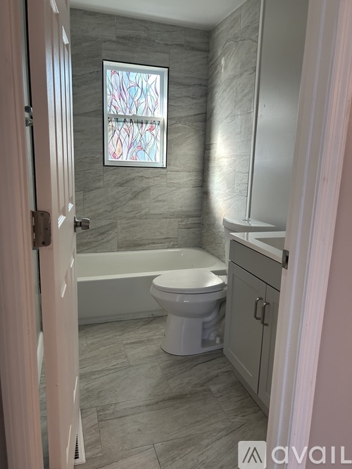 A bathroom with a tub, toilet and sink.