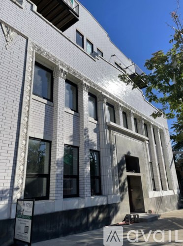 A white building with a black sign in front of it.