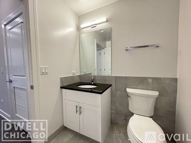 A white toilet sits next to a sink in a small bathroom.