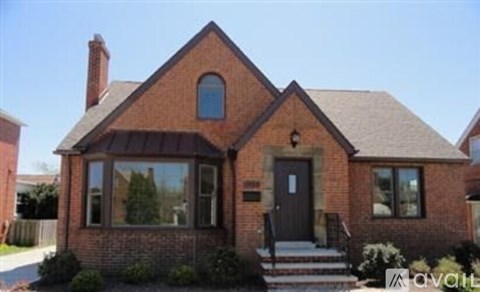 A brick house with a black door and a small porch.