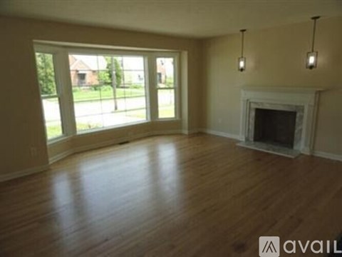 A living room with a fireplace and a large window.