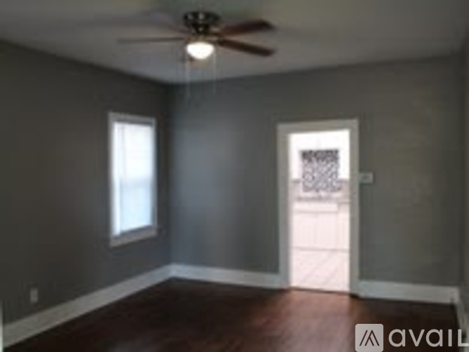 A room with a ceiling fan and a door leading to a balcony.
