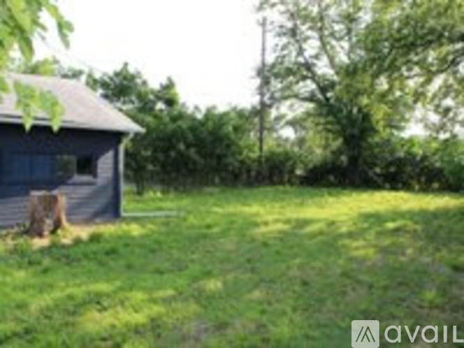 A small blue building sits in a grassy field.