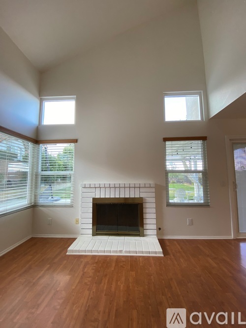 A living room with a fireplace and wooden floors.
