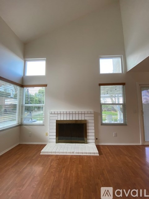 A living room with a fireplace and wooden floors.