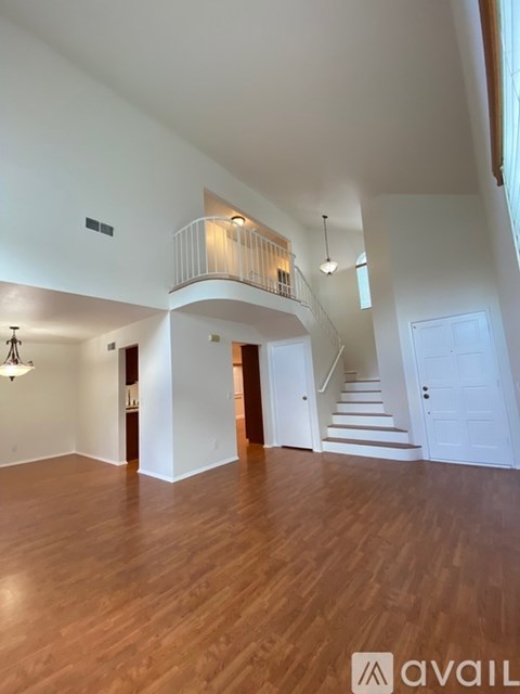 A spacious room with wooden floors and a balcony.