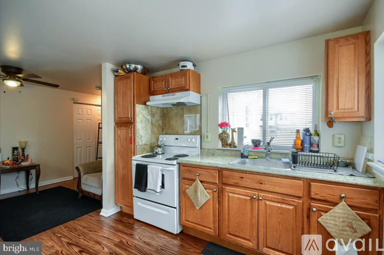 A kitchen with wooden cabinets and a white stove top oven.