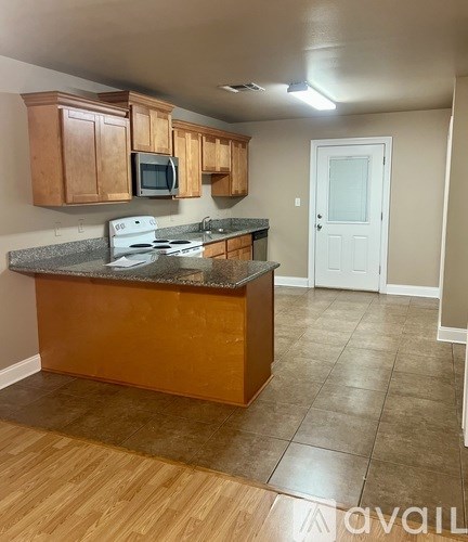 A kitchen with wooden cabinets and a granite countertop.