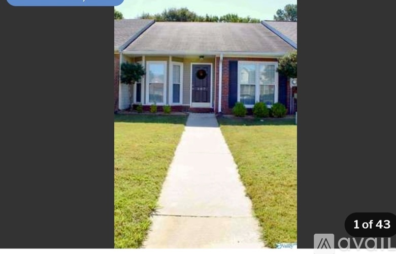 A house with a brown door and a white pathway leading to it.