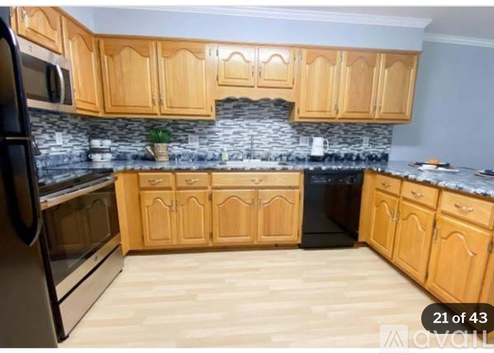 A kitchen with wooden cabinets and a stone backsplash.