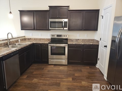 A kitchen with dark brown cabinets and a stainless steel refrigerator.