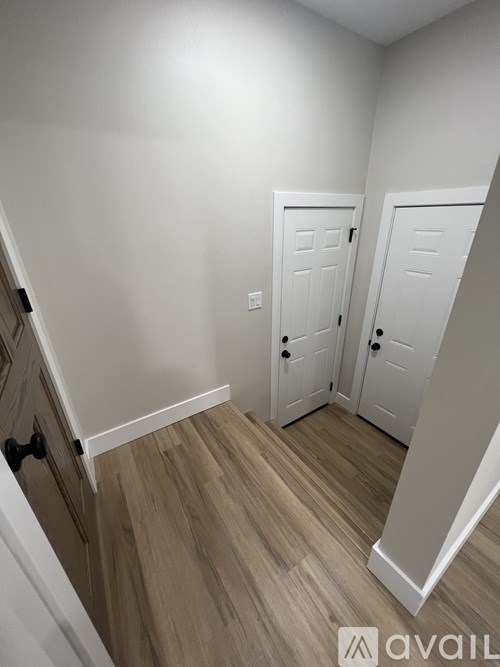 A hallway with two doors and a staircase.