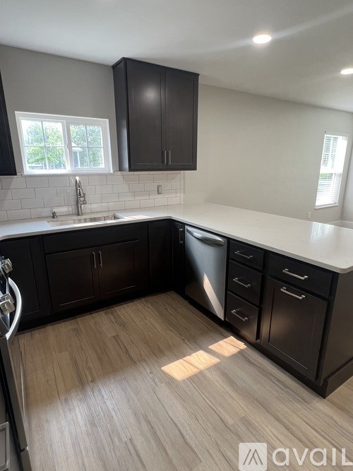 A kitchen with dark wood cabinets and a white countertop.
