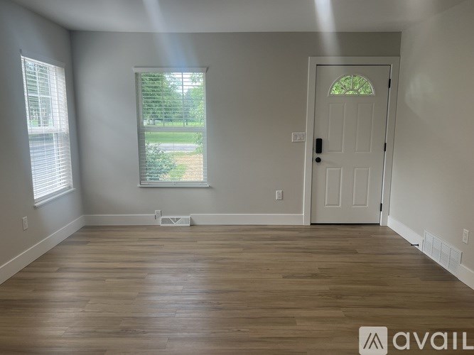 A room with a white door and a window with blinds.