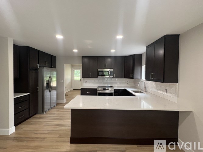 A modern kitchen with dark wood cabinets and a white island.