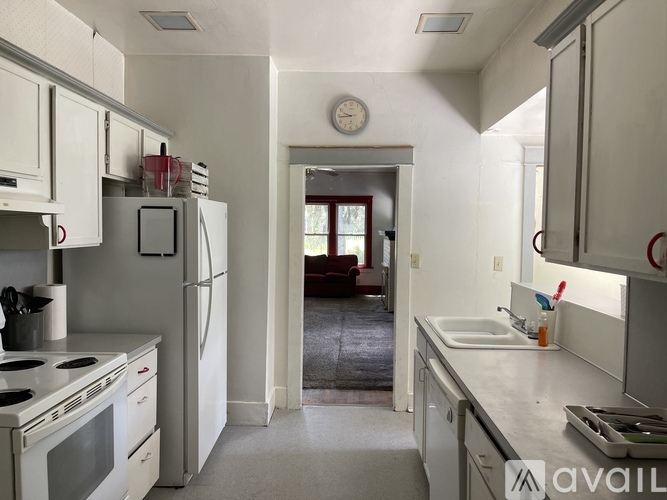 A kitchen with white appliances and cabinets.
