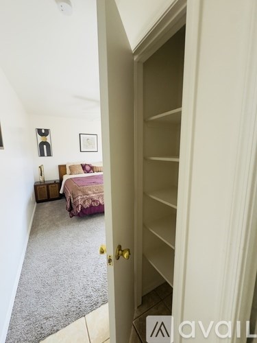 A bedroom with a bed and a dresser is visible through an open door.