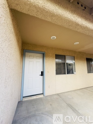 A white door is on the left side of a tan wall.