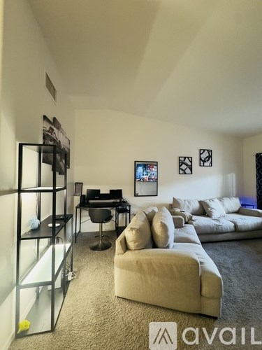 A living room with a couch, chair, and a television.
