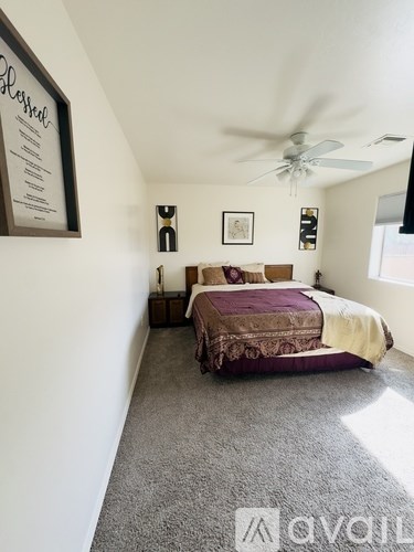 A bedroom with a bed and a ceiling fan.