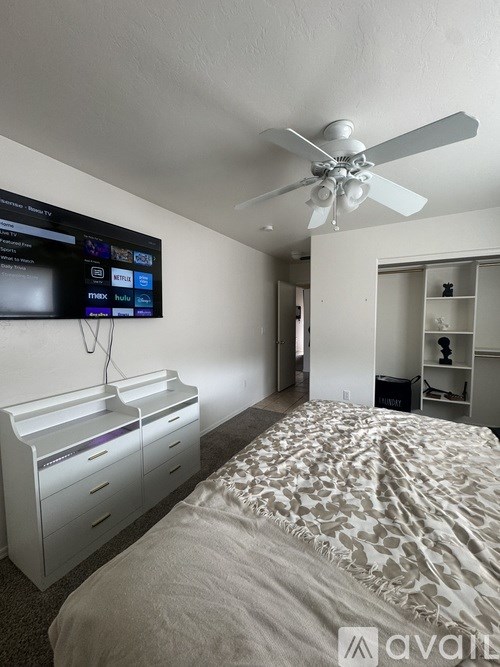A bedroom with a large bed and a flat screen TV mounted on the wall.