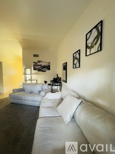 A living room with a grey couch and a white sofa.