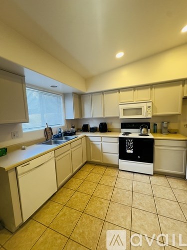 A kitchen with a white oven and beige cabinets.