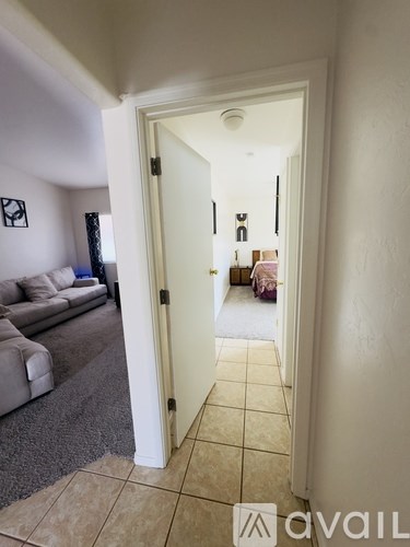 A hallway with a doorway leading to a living room.