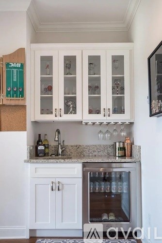 A kitchen with white cabinets and a marble countertop.