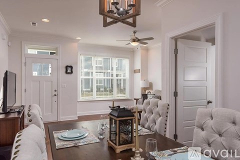 A dining room with a wooden table set for two.