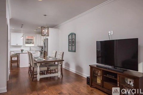 A living room with a television and a dining table.