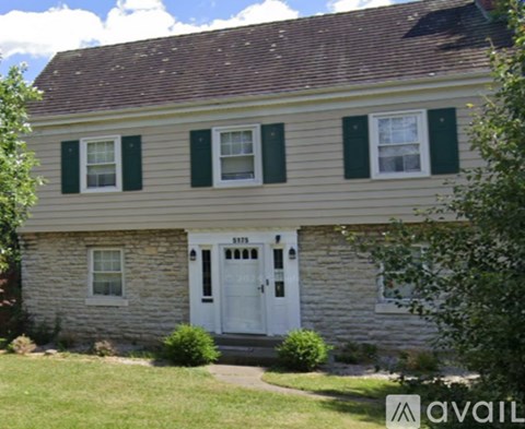 A house with a white door and green shutters.