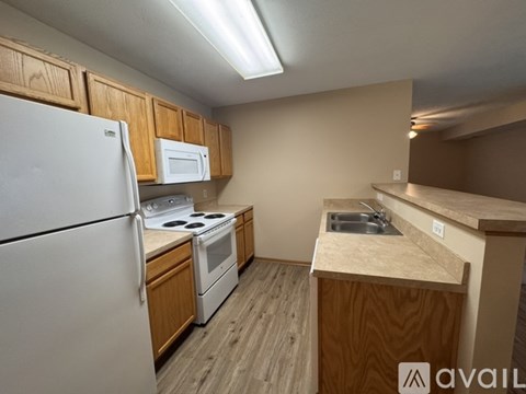 A kitchen with a white refrigerator, white stove, and white microwave.